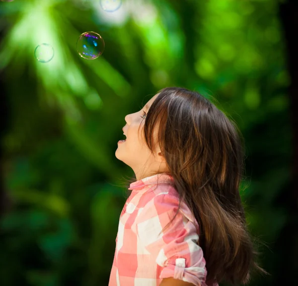 Menina assistindo bolhas de sabão — Fotografia de Stock