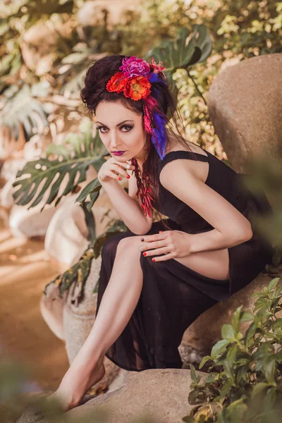 Chica sentada en las rocas junto al arroyo — Foto de Stock