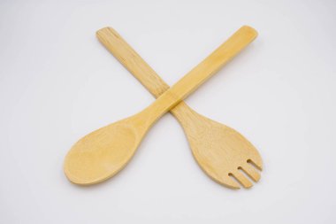 Beyaz arka planda ahşap salata çatalı.