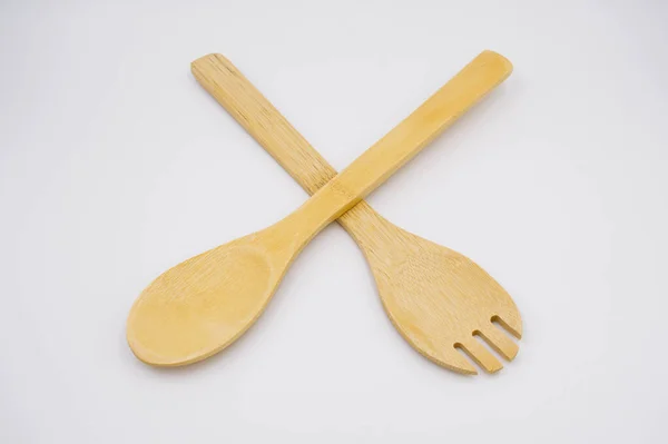 Beyaz arka planda ahşap salata çatalı.