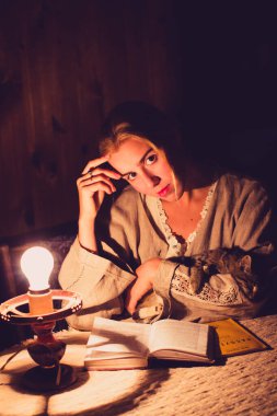 Küçük bir kediyle kitap okuyan şirin bir köy kızı.