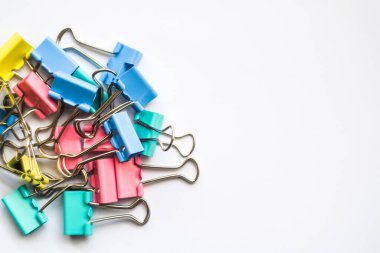 Renkli demir ataçlar. Beyaz zemin üzerinde izole edilmiş bir çok eşsiz pastel renk değişkenine sahip ataçlar, Binder atacı kağıt sayfalarını birbirine bağlamak için basit bir araçtır, kaos içindeki metal ataçlar