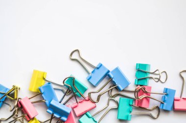 Renkli demir ataçlar. Beyaz zemin üzerinde izole edilmiş bir çok eşsiz pastel renk değişkenine sahip ataçlar, Binder atacı kağıt sayfalarını birbirine bağlamak için basit bir araçtır, kaos içindeki metal ataçlar