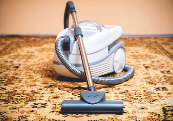 Aspirador en una alfombra persa . — Foto de Stock