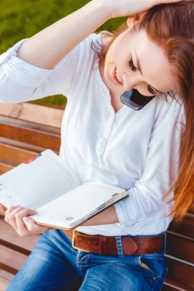 Young woman in the park with phone — Stock Photo, Image