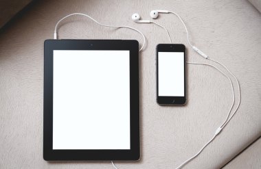 Tablet ve kanepenin üstünde hareket eden telefon