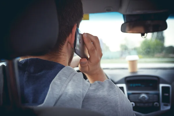 Young man driving a car with phone — Stock Photo, Image