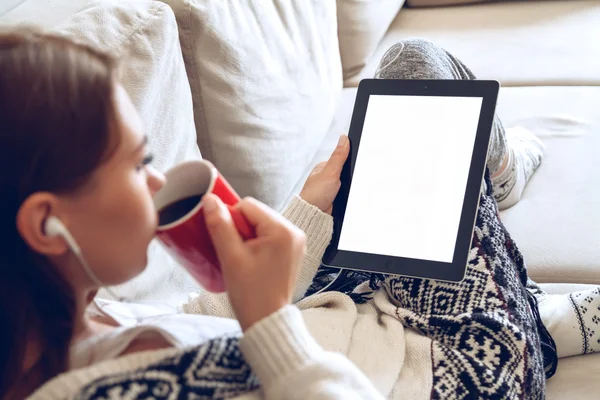 El tablet ve kahve ile kanepede oturan kadın