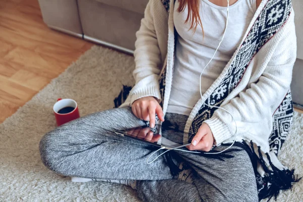 Mujer sentada en el sofá con tablet y café en la mano — Foto de Stock