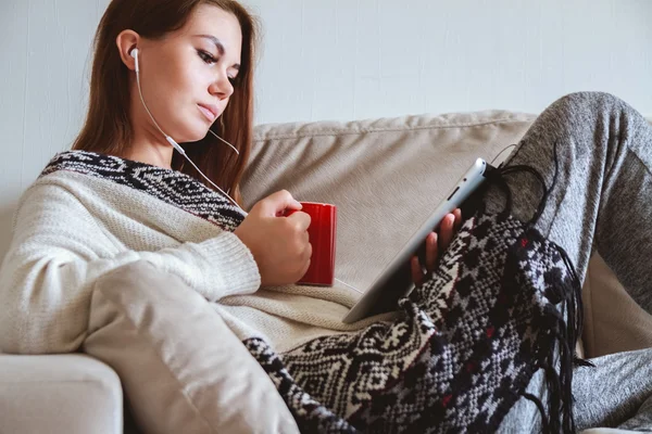 El tablet ve kahve ile kanepede oturan kadın — Stok fotoğraf