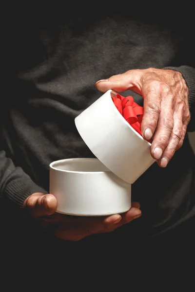 Gift in hands of the elderly man — Stock Photo, Image