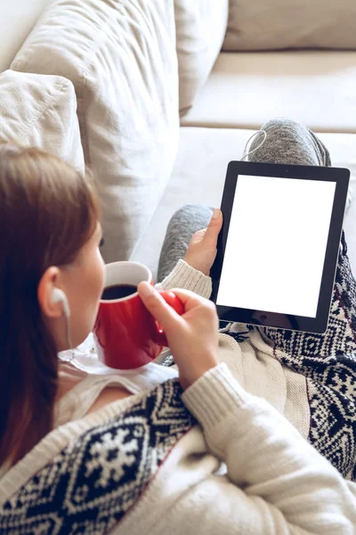 Mujer sentada en el sofá con tablet y café en la mano —  Fotos de Stock