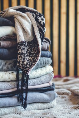 Sıcak, sıcak kışlık giysiler yığını yatağın üzerinde..