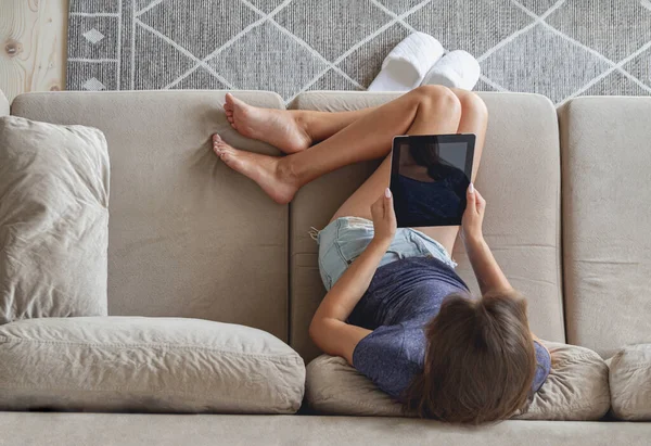 Mujer Joven Feliz Sentado Sofá Uso Tableta Casa —  Fotos de Stock