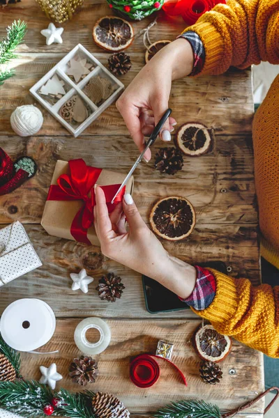 Yılbaşı hediyesini yeni yıl süslemeleriyle saran genç bir kadın.