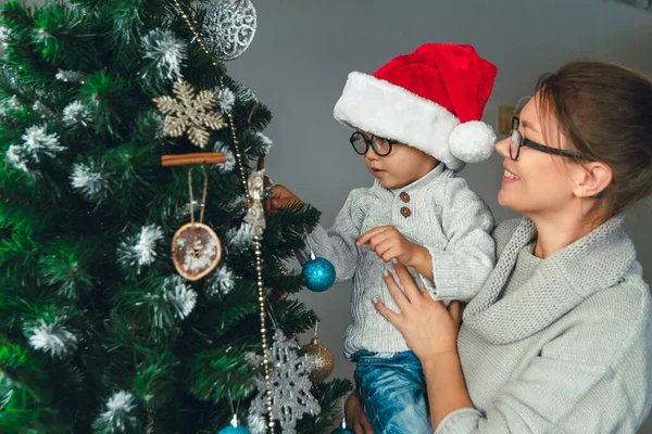 妈妈和她的孩子一起装饰圣诞树 — 图库照片