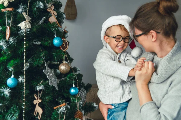 妈妈和她的孩子一起装饰圣诞树 — 图库照片