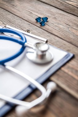 Mavi haplar, yakın çekim, steteskop ve hasta kayıtları.