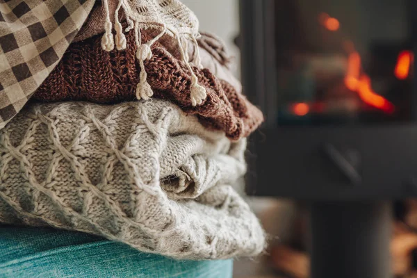 Una pila de ropa de abrigo en un sillón una chimenea de hierro con una — Foto de Stock