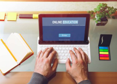 Masada oturan bir adam, dizüstü bilgisayarın arkasında çalışıyor. Model yap. Yukarıdan bak. Telework konsepti. Çevrimiçi eğitim kavramı