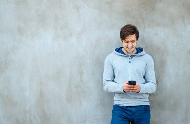 Genç adam yüz tanıma teknolojisi olan yeni bir akıllı telefon kullanıyor.