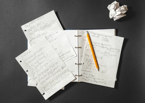 Λύνοντας Ένα Μαθηματικό Πρόβλημα Ένα Σημειωματάριο Θρυμματισμένο Χαρτί Μαύρο Γραφείο — Φωτογραφία Αρχείου
