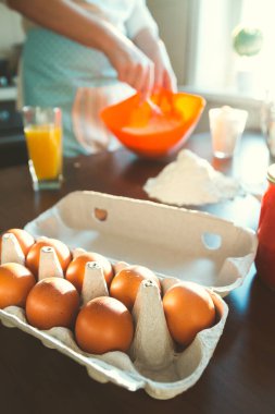 Pasta yapmak için gerekli malzemeler. Genç bir kadının arka planına karşı hamur hazırlar.