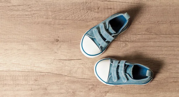 木製の床にかわいい赤ちゃんの青いスニーカー — ストック写真