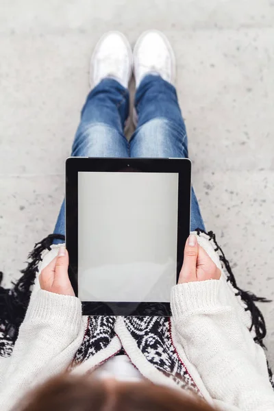 Elinde boş ekranlı tablet tutan genç bir kadın..