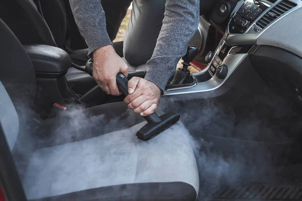 cleaning and disinfecting by steam of the car interior and a car seats with a steam cleaner