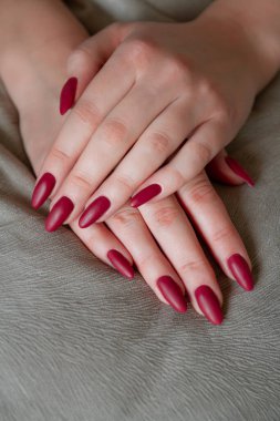 Model woman showing red shellac manicure on the long nails