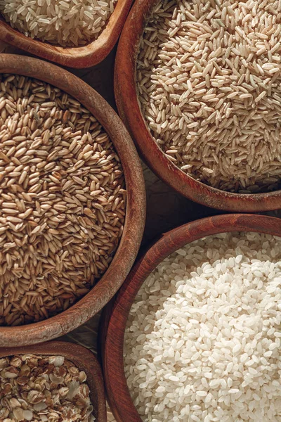 Set of different types of rice and cereals in the wooden bowls