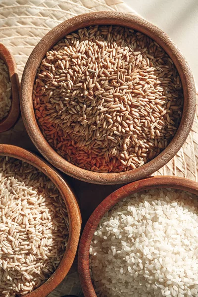 Set of different types of rice and cereals in the wooden bowls