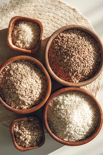 Set of different types of rice and cereals in the wooden bowls