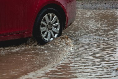 Araba çamura saplanmış, araba tekerleği kirli su birikintisi, engebeli arazi