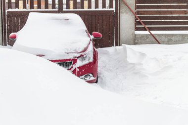 Kar bir kar yığınına park edilmiş arabayı kapladı.