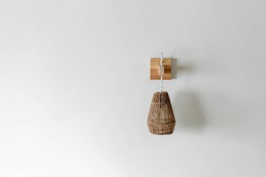 Ahşap duvara monte edilmiş halat lamba armatürü.