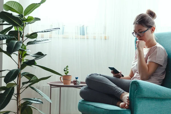 Mujer Joven Usando Teléfono Móvil Mientras Está Sentado Sillón Acogedor — Foto de Stock