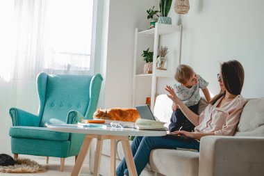 Evde ve evde çalışma kavramı, evde dizüstü bilgisayarla çalışma, yakınlarda oynayan çocuk