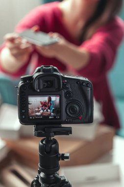 Kamera ekranını kapat, kadın blogcu evde paketleri açarken video çekiyor