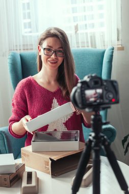 Kamera ekranını kapat, kadın blogcu evde paketleri açarken video çekiyor