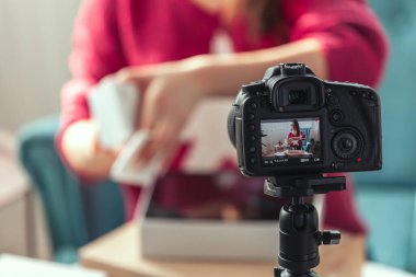 Kamera ekranını kapat, kadın blogcu evde paketleri açarken video çekiyor