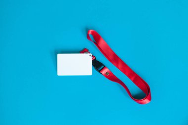 Beyaz plastik rozet ve boş alan ile kırmızı Lanyard mavi arkaplan üzerinde izole taklit