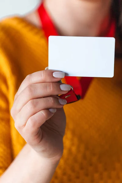 Woman holding badge name tag with blank space mock up