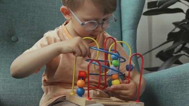 Criança jogando contas de labirinto de fio de madeira em casa. Brinquedo de jogo educativo. aprender cor e forma — Vídeo de Stock