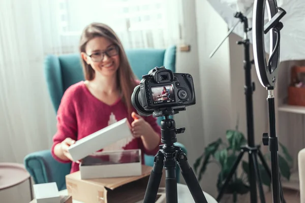 Close-up the camera screen, woman blogger makes video of unpacking gadgets at home