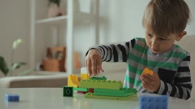 Evde renkli bina plastiği bloklarıyla oynayan çocuk