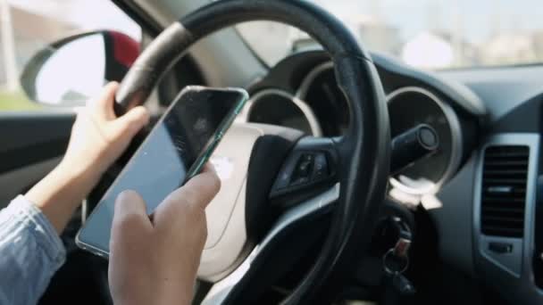 Жінка керує текстовим повідомленням автомобіля на мобільному телефоні в русі, а не текстом і приводом — стокове відео
