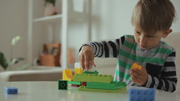 Criança brincando com edifício colorido blocos de plástico construtor em casa — Vídeo de Stock