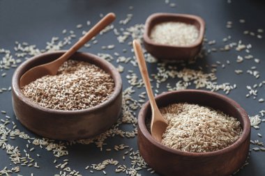 Tahta kaselerde farklı pirinç ve tahıl ve bambu kaşıkları var.